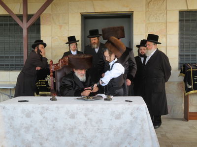 האדמו"ר מויז'ניץ בהנחת תפילין לנכדו משה יהושע הגר