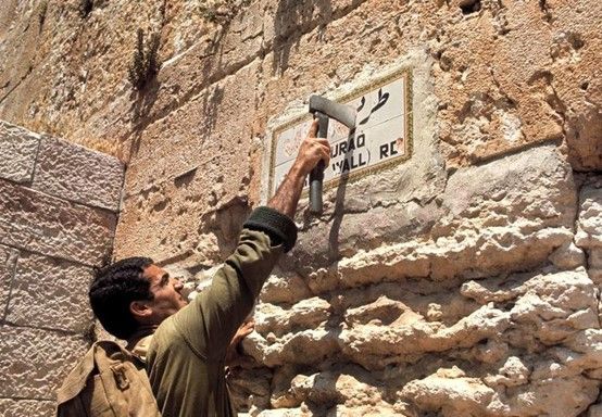 כתב העיתון הדתי-צהל"י 'מחניים' דוד קוליץ מסיר את השלט בהוראת הזקן