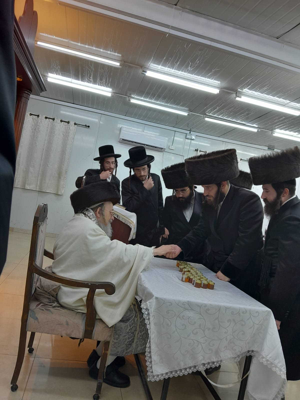 האדמו"ר מקאליש בחלוקת צנצנות דבש לאחר סליחות