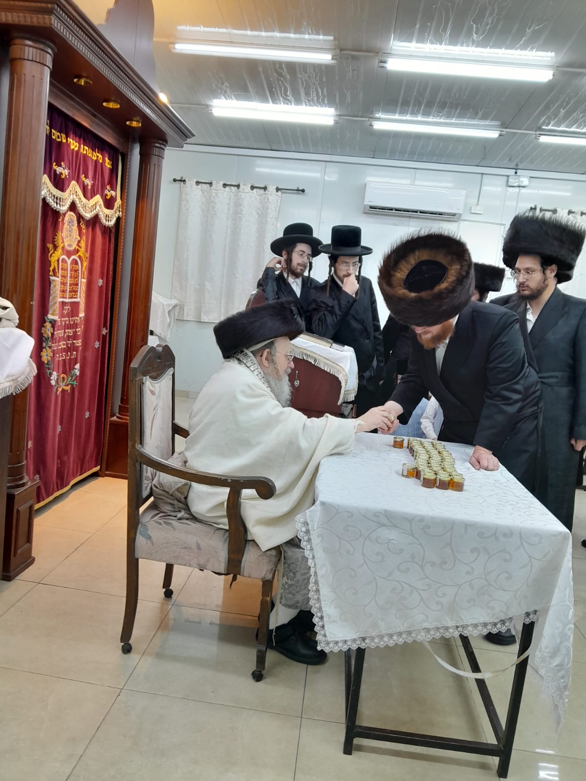 האדמו"ר מקאליש בחלוקת צנצנות דבש לאחר סליחות