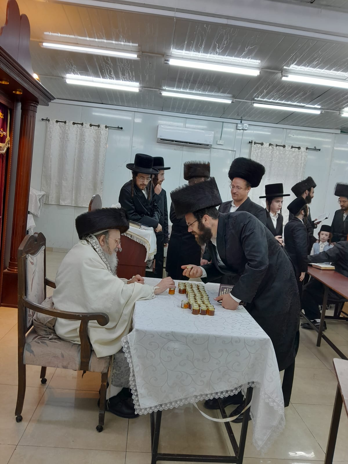 האדמו"ר מקאליש בחלוקת צנצנות דבש לאחר סליחות