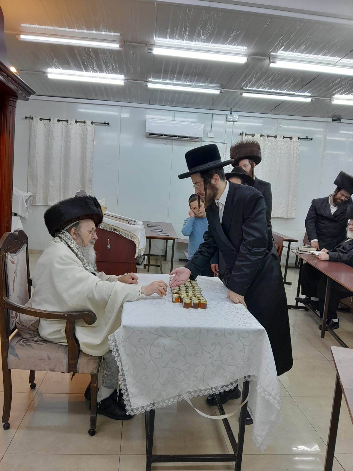 האדמו"ר מקאליש בחלוקת צנצנות דבש לאחר סליחות