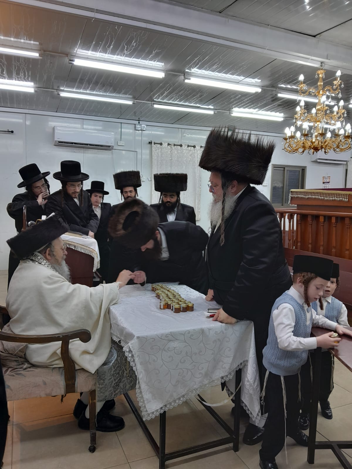 האדמו"ר מקאליש בחלוקת צנצנות דבש לאחר סליחות