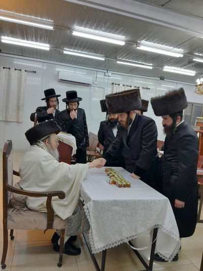 האדמו"ר מקאליש בחלוקת צנצנות דבש לאחר סליחות