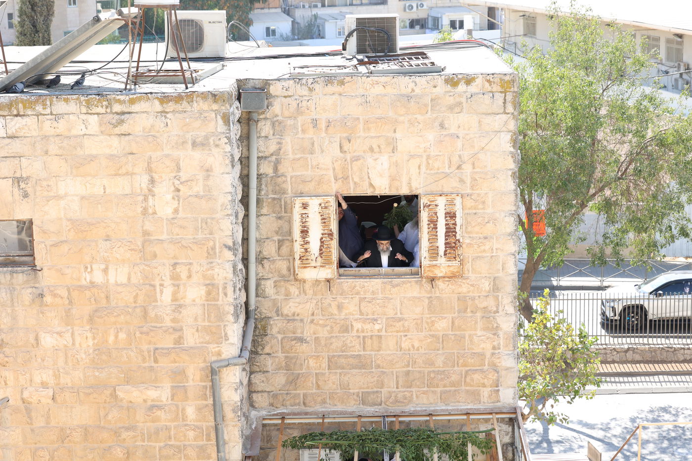 הגאון הרב משה צדקה מסכך את סוכתו