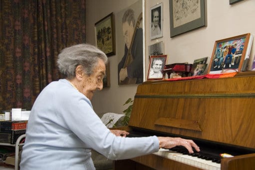 עליזה הרץ-זומר בנגינה על פסנתר בביתה שבלונדון בסוף ימיה