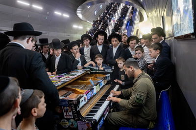 חייל חרדי מנגן בתחנת הרכבת בעצרת היום