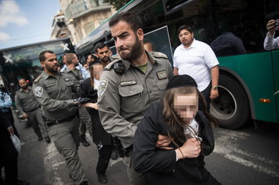 שוטר עוצר נער חרדי בהפגנה | ארכיון 