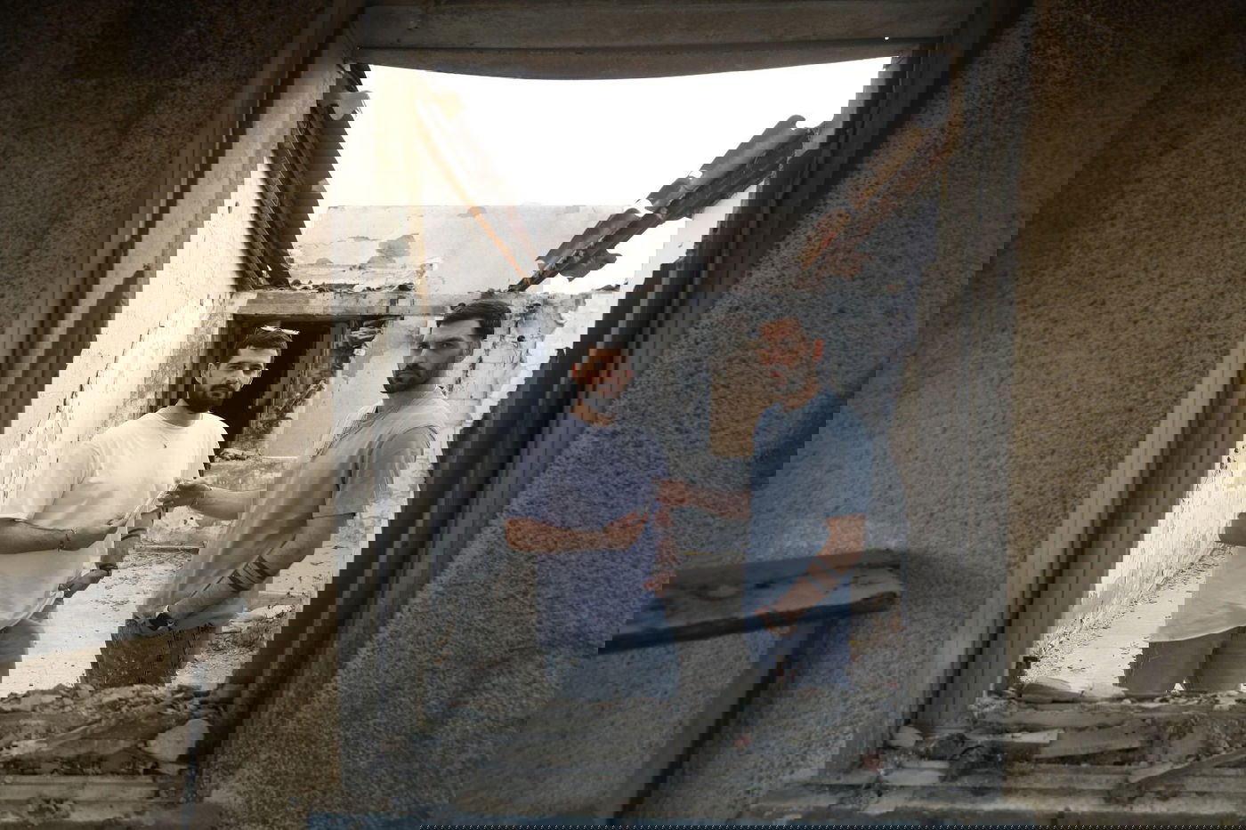 התאומים ברמן עם המזוזה ששרדה בבית השרוף