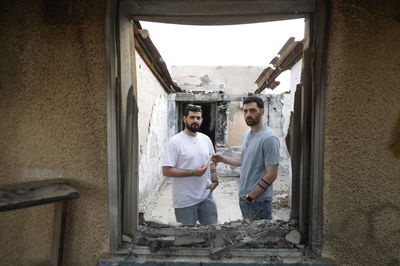 התאומים ברמן עם המזוזה ששרדה בבית השרוף