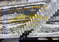 העוגה שהוגשה לנשיא ישיבת פוניבז' הגר"א כהנמן - עם תמונת ישיבת פוניבז' בהכנסת ספר תורה לע"נ ראש הישיבה הגרי"ג אדלשטיין זצוק"ל