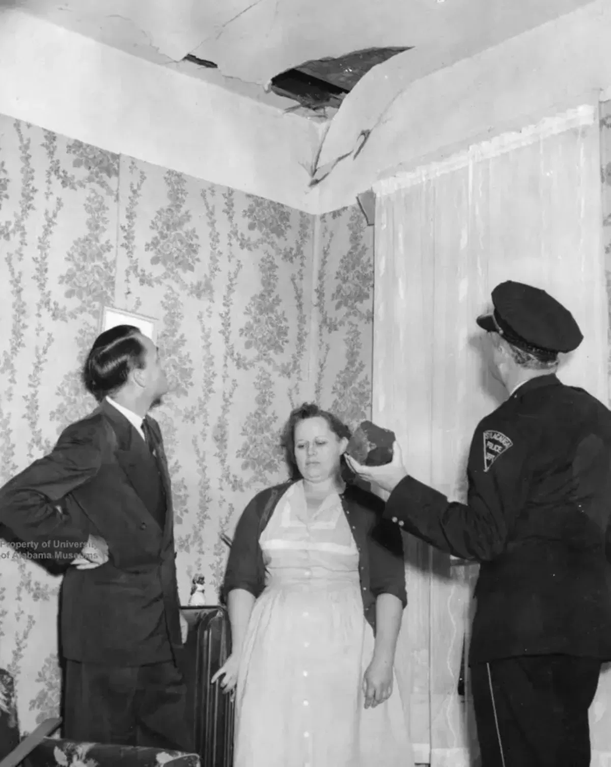 ראש העיר אד ג'יי הווארד, מפקד המשטרה אן הודג'ס וו. ד. אשקרופט בודקים את החור בגג.  