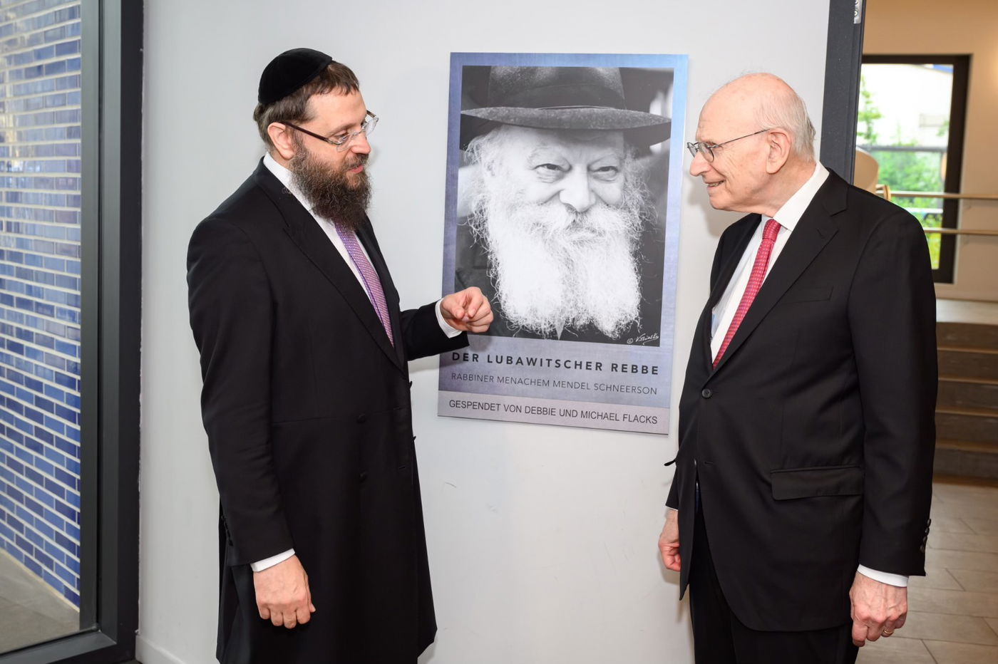 אייזנשטט בברלין, לצד תמונת הרבי מליובאוויטש, בשיחה עם הרב יהודה טייכטל