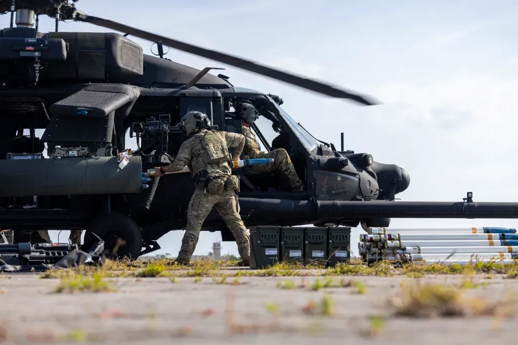 חייל צבא ארה״ב טוען רקטות למסוק MH-60 Black Hawk