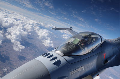 מטוס קרב F-16 טס גבוה מעל העננים