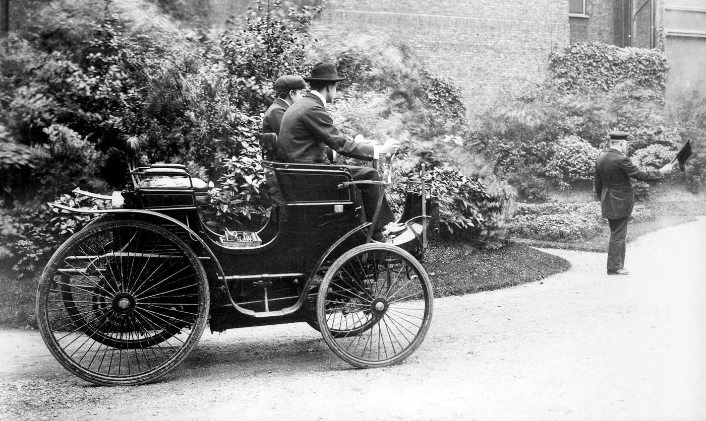 שני אנשים ברכב ואדם מהלך לפניהם עם דגל אדום. חוק הדגל האדום