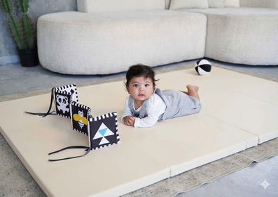 תמונה של תינוק על משטח פעילות עם צעצועים להתפתחות