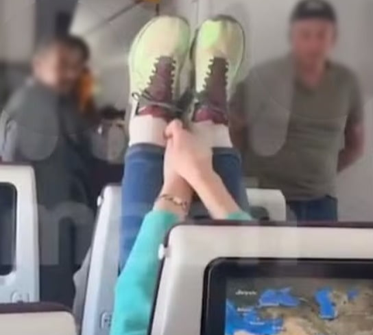 הנוסעת מניחה רגליים על המושב שלפניה