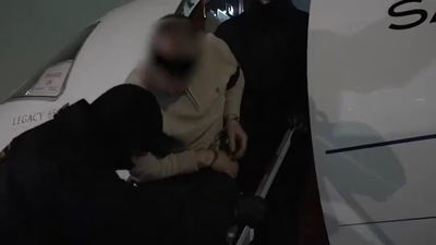 אזוק ובעיניים מכוסות: כך נראה רגע ירידתו מהמטוס של החשוד בהתנקשות 