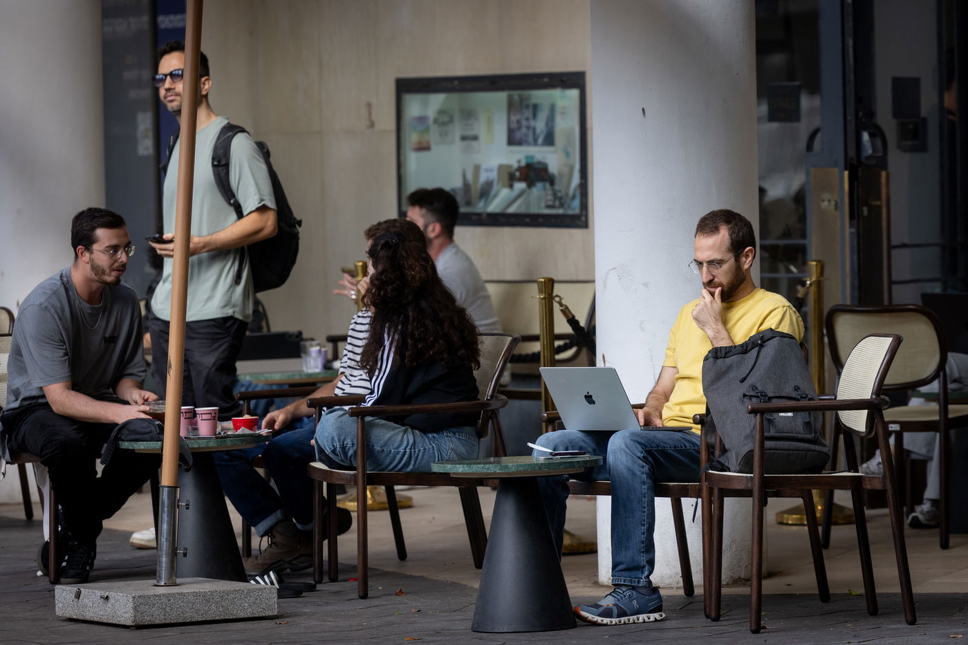 כבר לא במשרדים. צעירים בבית קפה במהלך יום עבודה