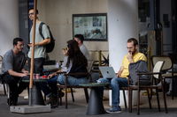 כבר לא במשרדים. צעירים בבית קפה במהלך יום עבודה