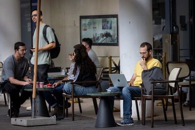 כבר לא במשרדים. צעירים בבית קפה במהלך יום עבודה