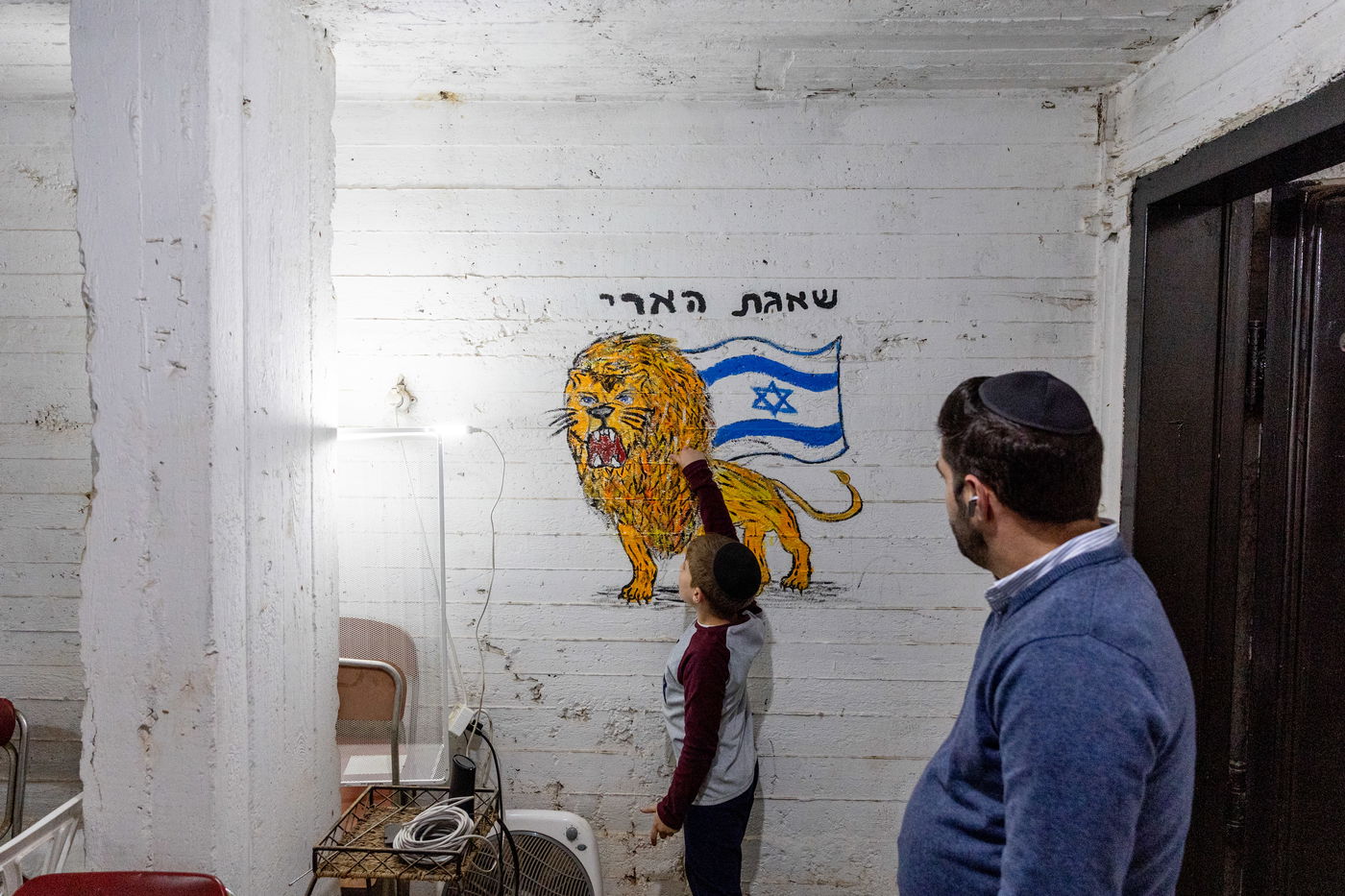 ילד מצייר על קיר מקלט בפתח תקוה במהלך האזעקות במבצע שאגת הארי