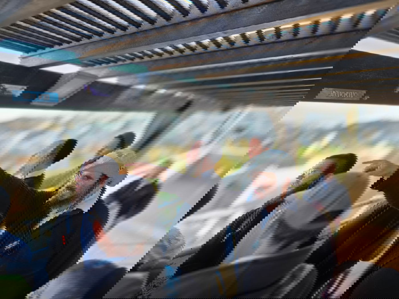 תצפית תל חברון מעל בית מנחם. מדריך הטיולים אברהם דוידוביץ מראה את בנין ישיבת סלבודקא בשטח A