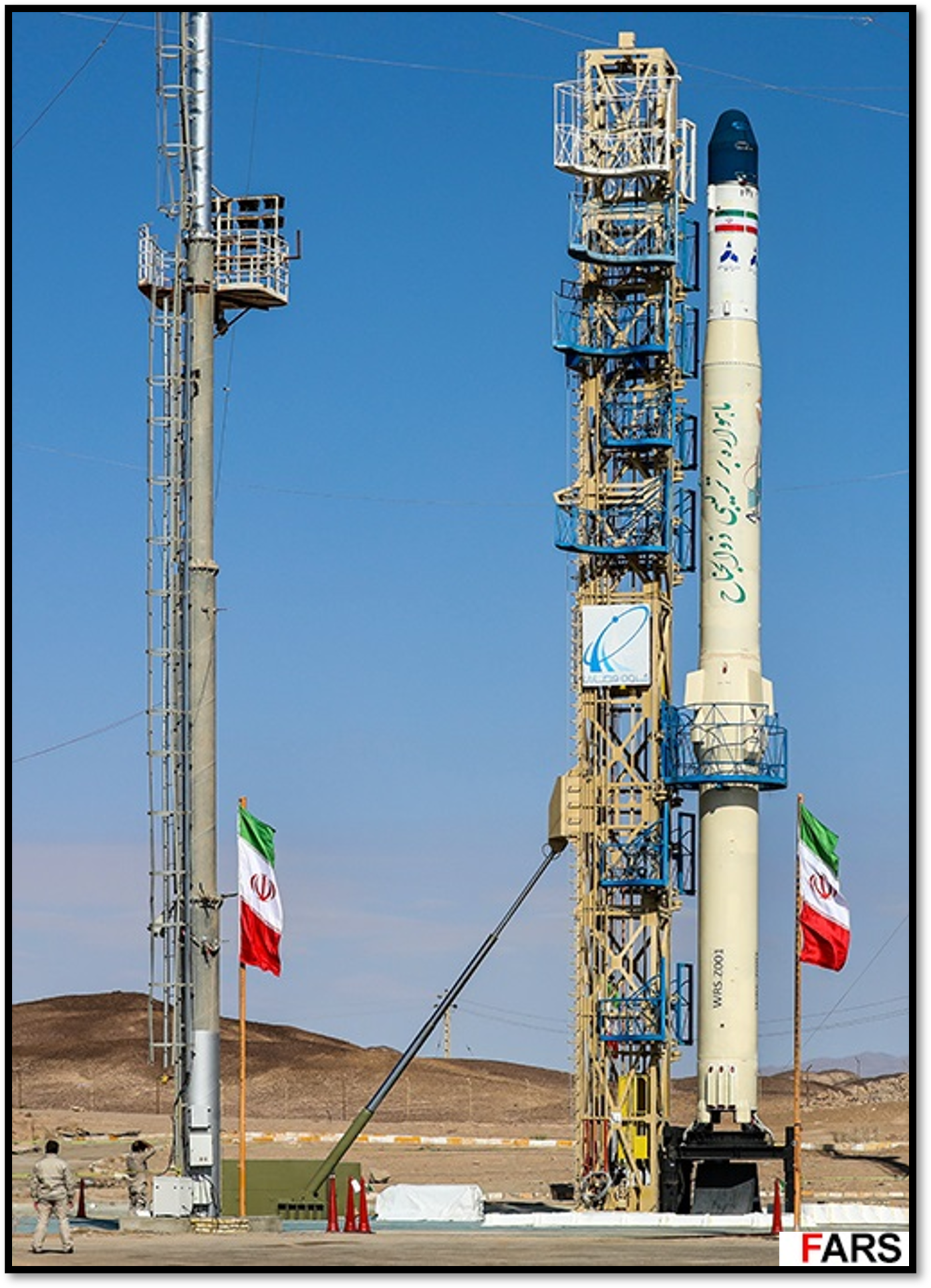 משגר הלוויינים האיראני "זולג'נאח" (Zuljanah) על כנה השיגור במרכז החלל בסמנאן, לצד מגדל שירות ודגלי איראן.