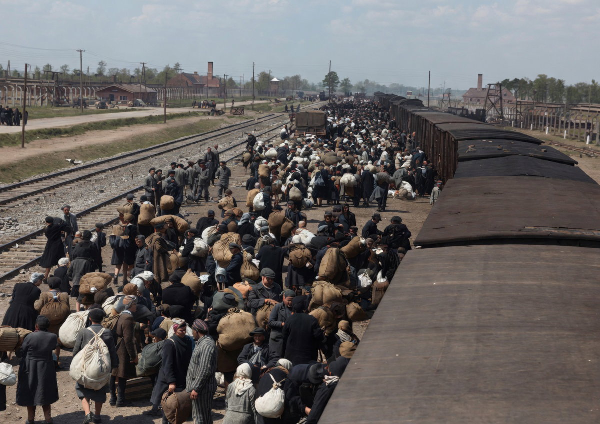 הקרונות נפתחים בטריקה, אוויר צח מתערבב בריח המוות, והיהודים נדחפים החוצה אל הלא נודע באלימות קשה וצעקות גרמניות