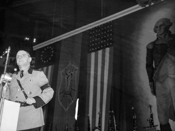 פרנץ קון באחד מנאומיו הארסיים בארה"ב כשברקע דיוקנו של ג'ורג' וושינגטון 