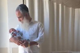 חיוך של ניצחון: הלוחם החסידי שאיבד את שתי רגליו חובק בן שישי