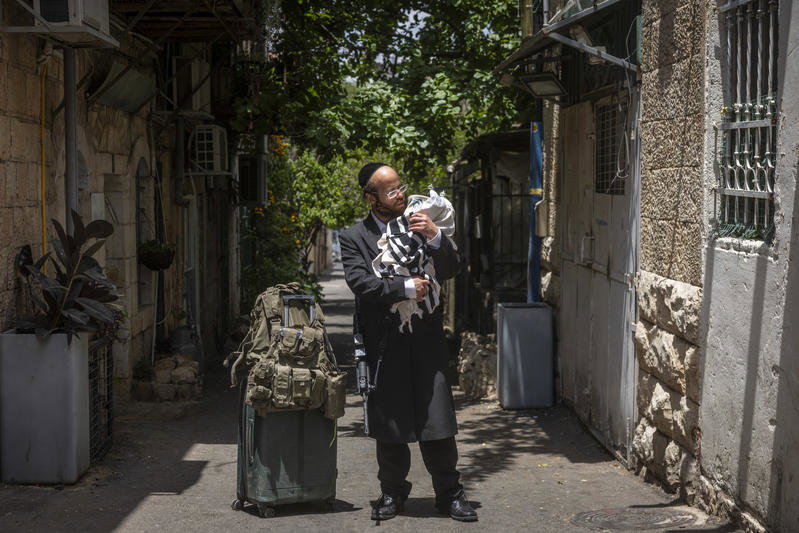 חסיד גור תועד בדרך למילואים; אנשים נעצרו לנשק את ספר התורה שבידיו