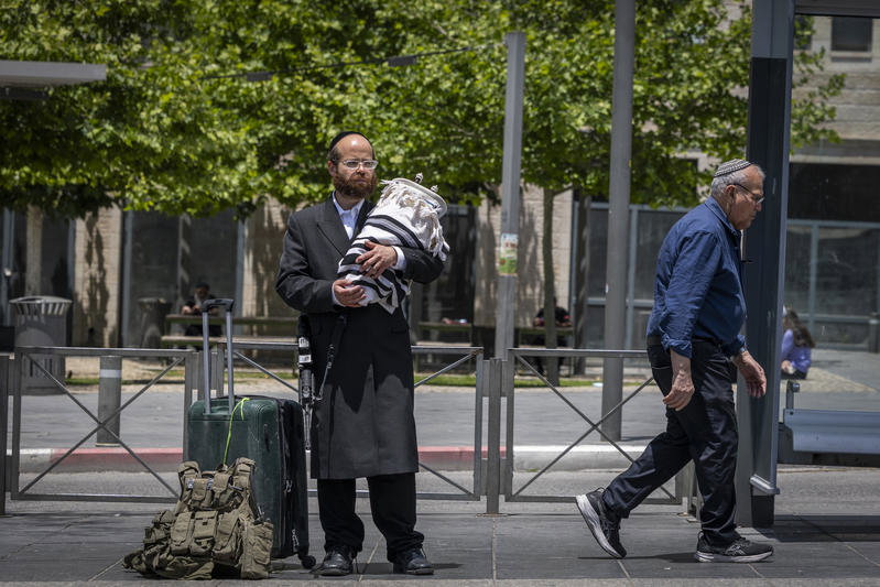 חסיד גור תועד בדרך למילואים; אנשים נעצרו לנשק את ספר התורה שבידיו
