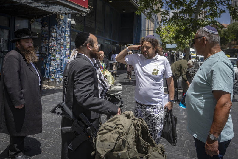 חסיד גור תועד בדרך למילואים; אנשים נעצרו לנשק את ספר התורה שבידיו
