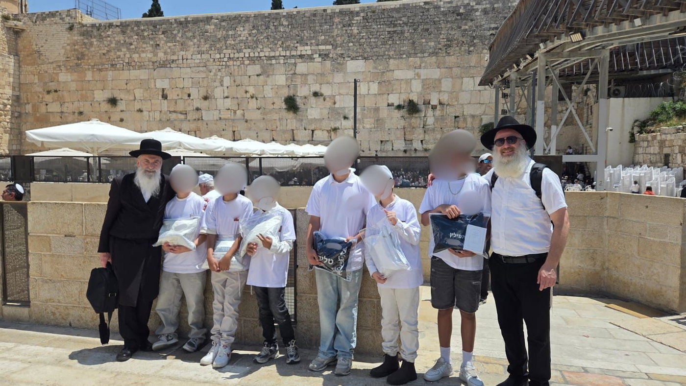 הניצולים חתני המצוות ברחבת הכותל המערבי השבוע, בחברת הרב זאב רובינסון והרב חיים קאהן, פעילי יד לאחים