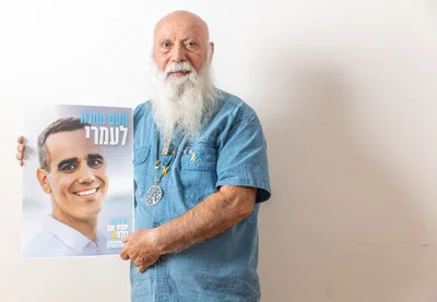 דני מירן עם תמונת בנו במהלך המאבק להשבת החטופים