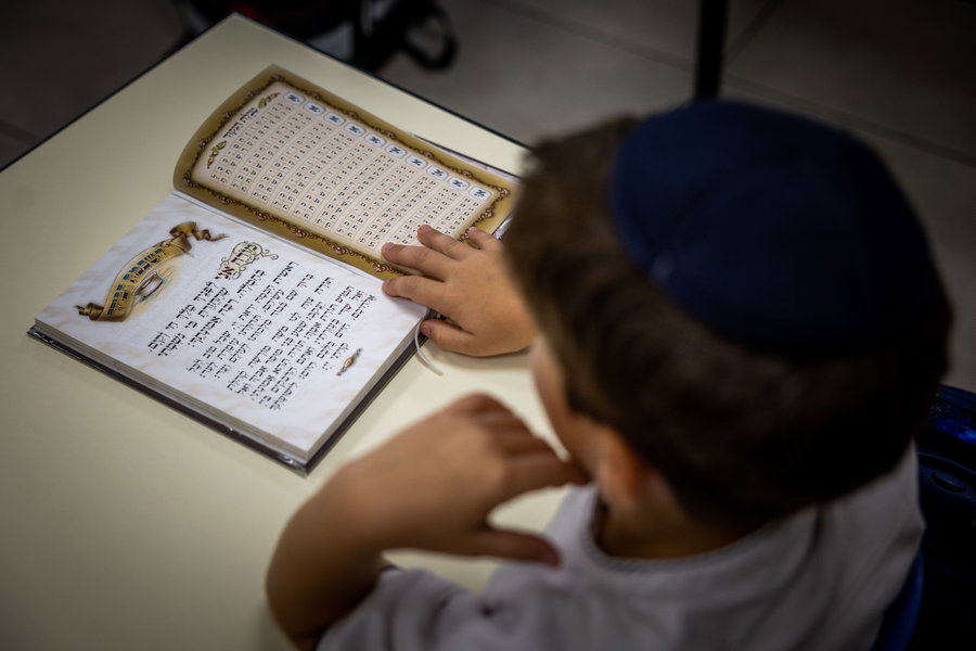 ילד מתפלל שחרית בכיתה