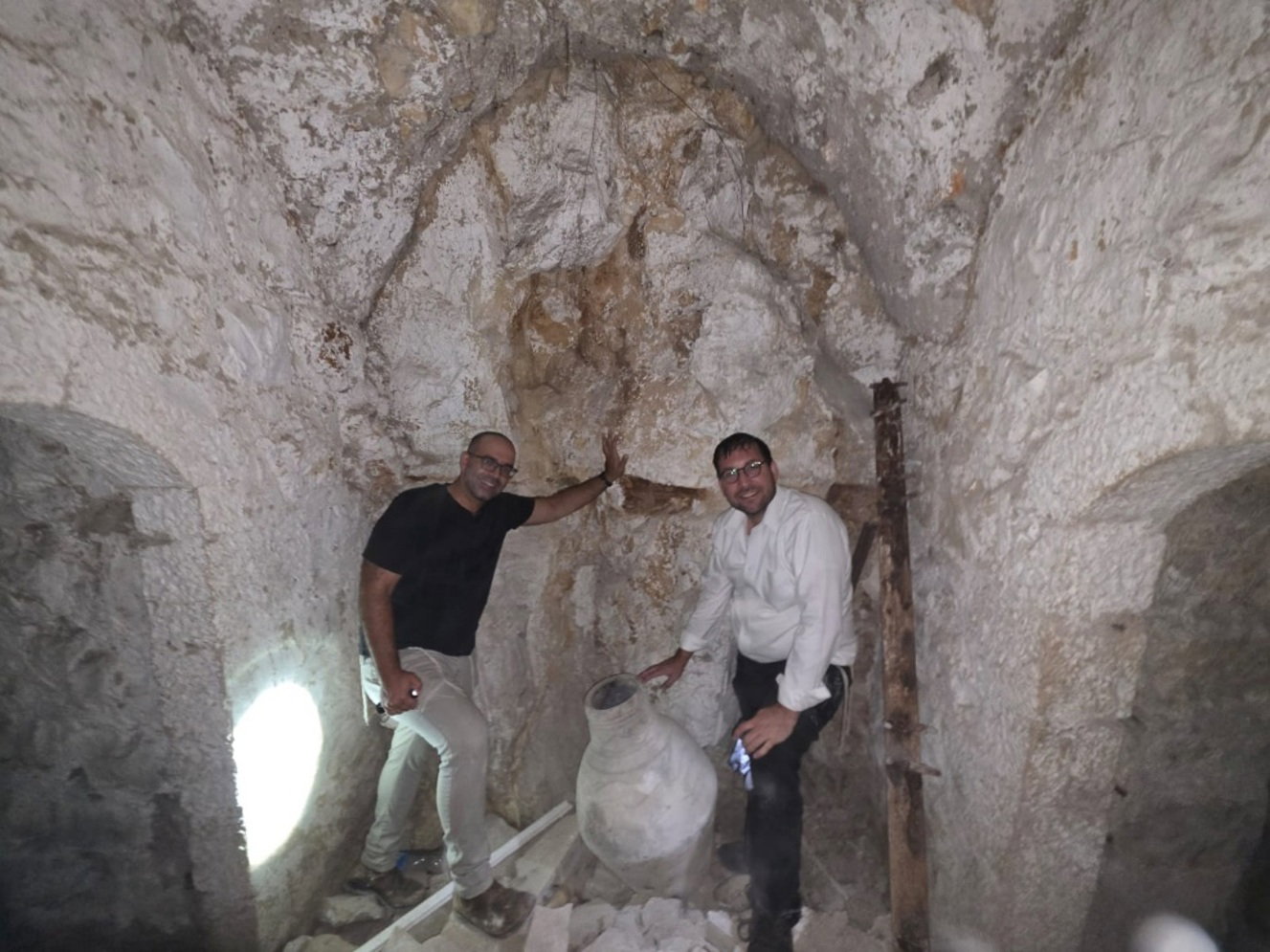 כותב השורות והארכיאולוג ד"ר עומרי עבאדי בוחנים קנקן אגירה ענק (מסוג "ג'רות") שנמצא במרתף חצר שטרויס