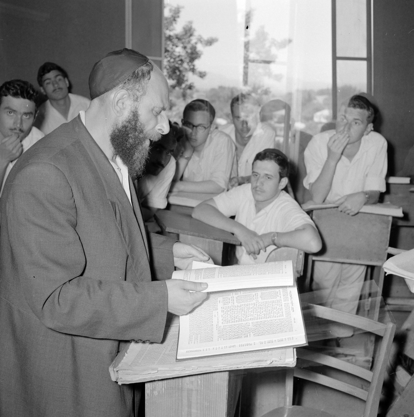 מבטים דרוכים, מחוות יד סוערת וספרים פתוחים: עולם התורה קם מחדש בצריפים.