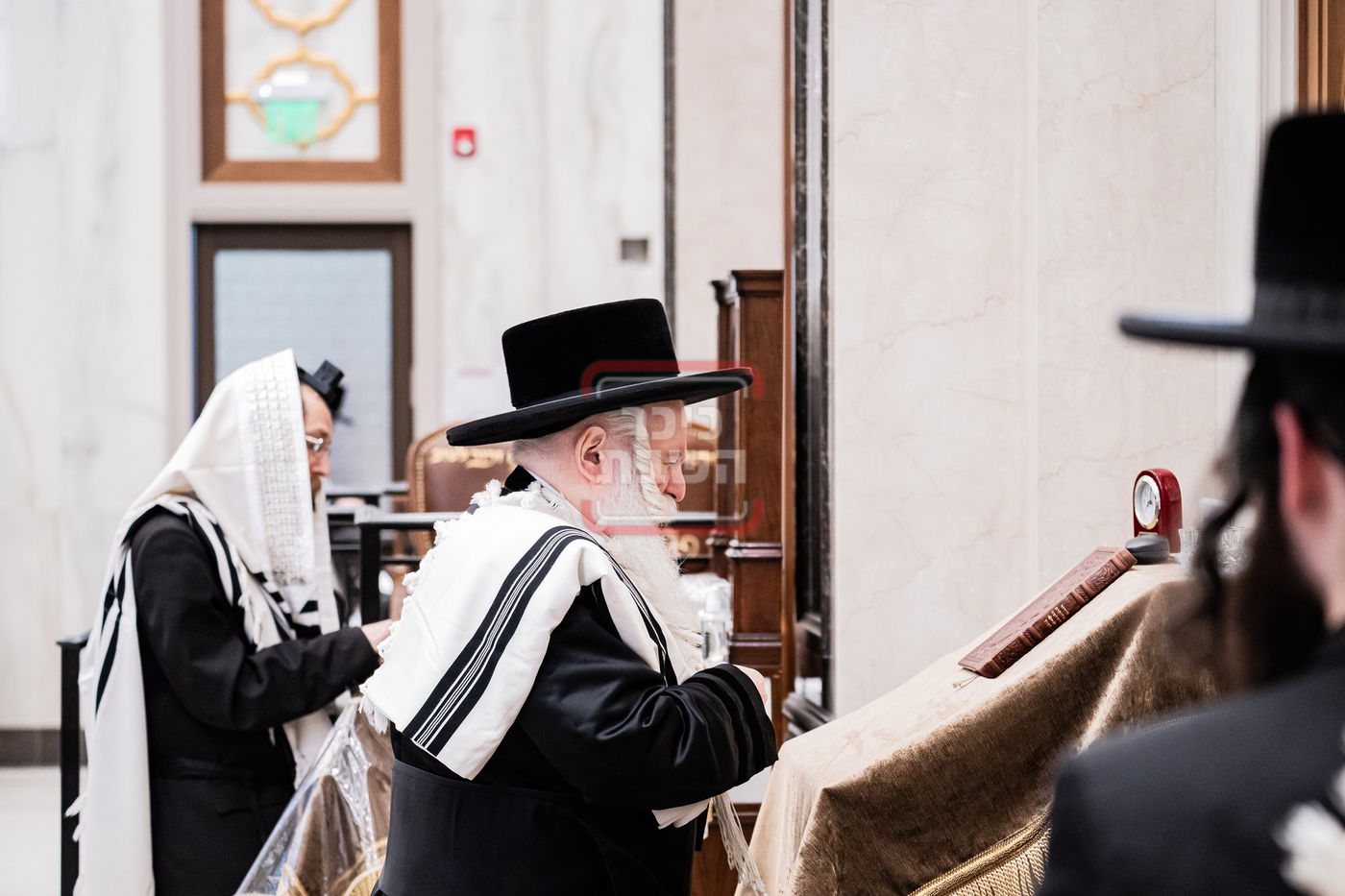 האדמו"ר מבאבוב מתעטף בטלית לפני תפילת שחרית במונסי