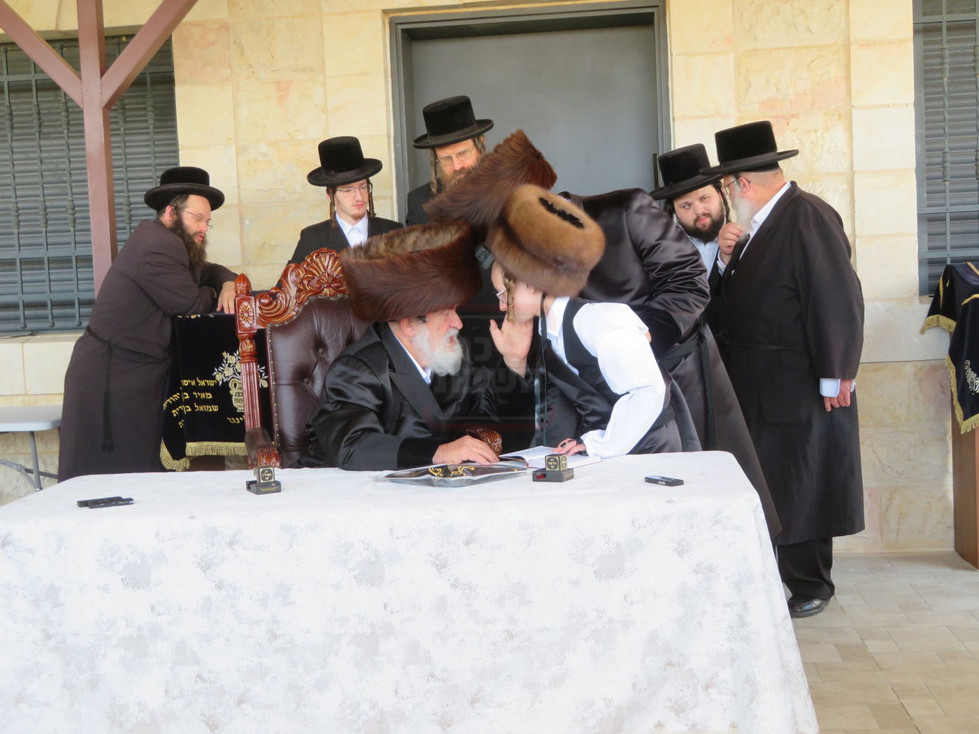 האדמו"ר מויז'ניץ בהנחת תפילין לנכדו משה יהושע הגר