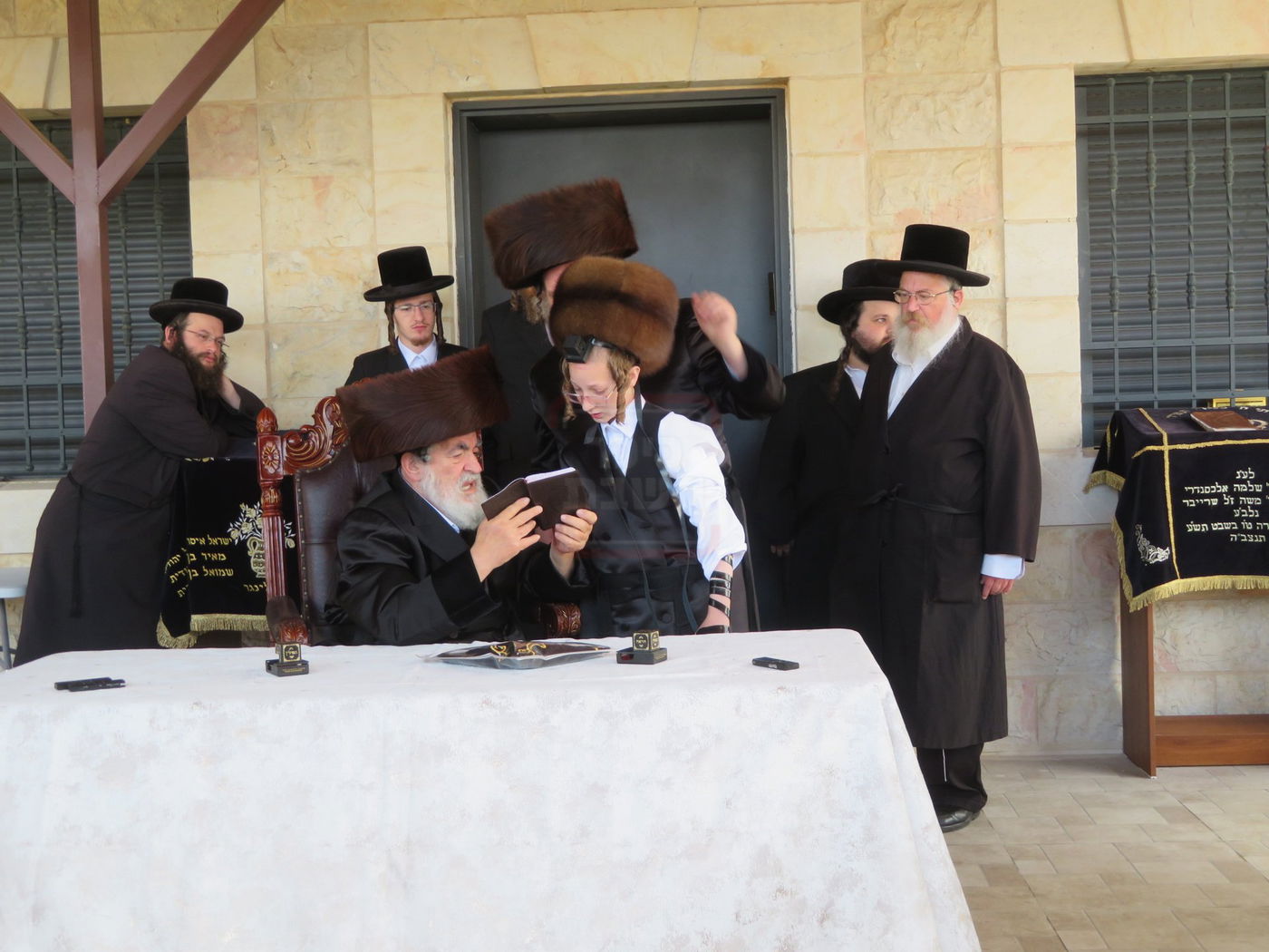 האדמו"ר מויז'ניץ בהנחת תפילין לנכדו משה יהושע הגר