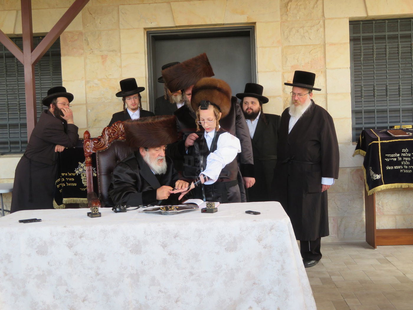 האדמו"ר מויז'ניץ בהנחת תפילין לנכדו משה יהושע הגר