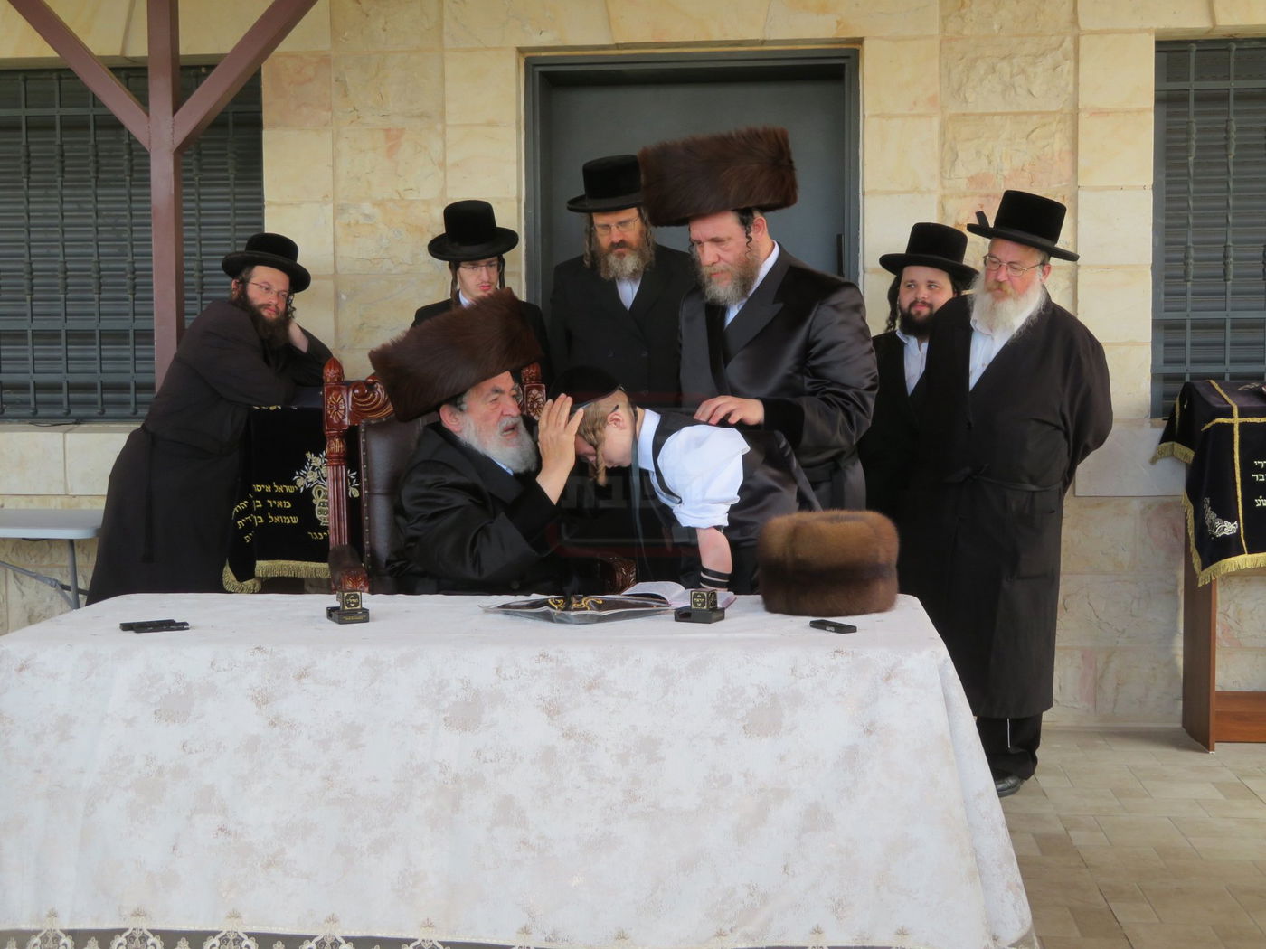 האדמו"ר מויז'ניץ בהנחת תפילין לנכדו משה יהושע הגר