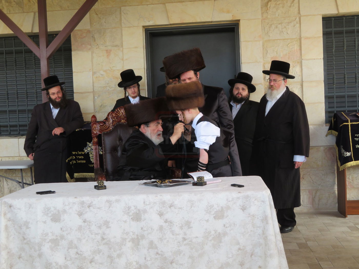 האדמו"ר מויז'ניץ בהנחת תפילין לנכדו משה יהושע הגר