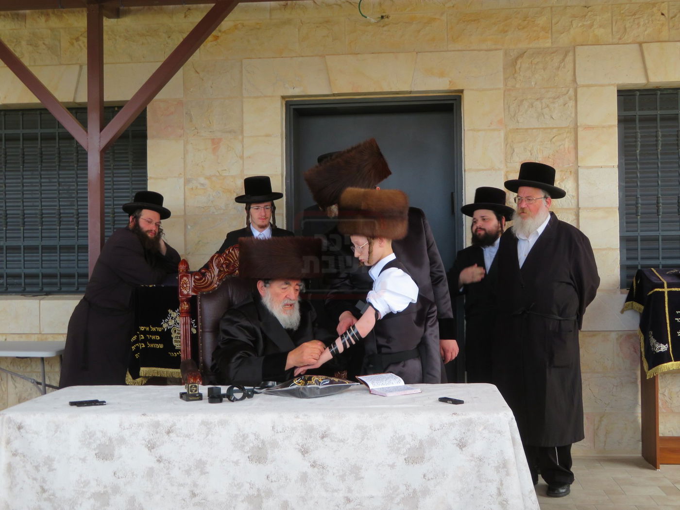 האדמו"ר מויז'ניץ בהנחת תפילין לנכדו משה יהושע הגר