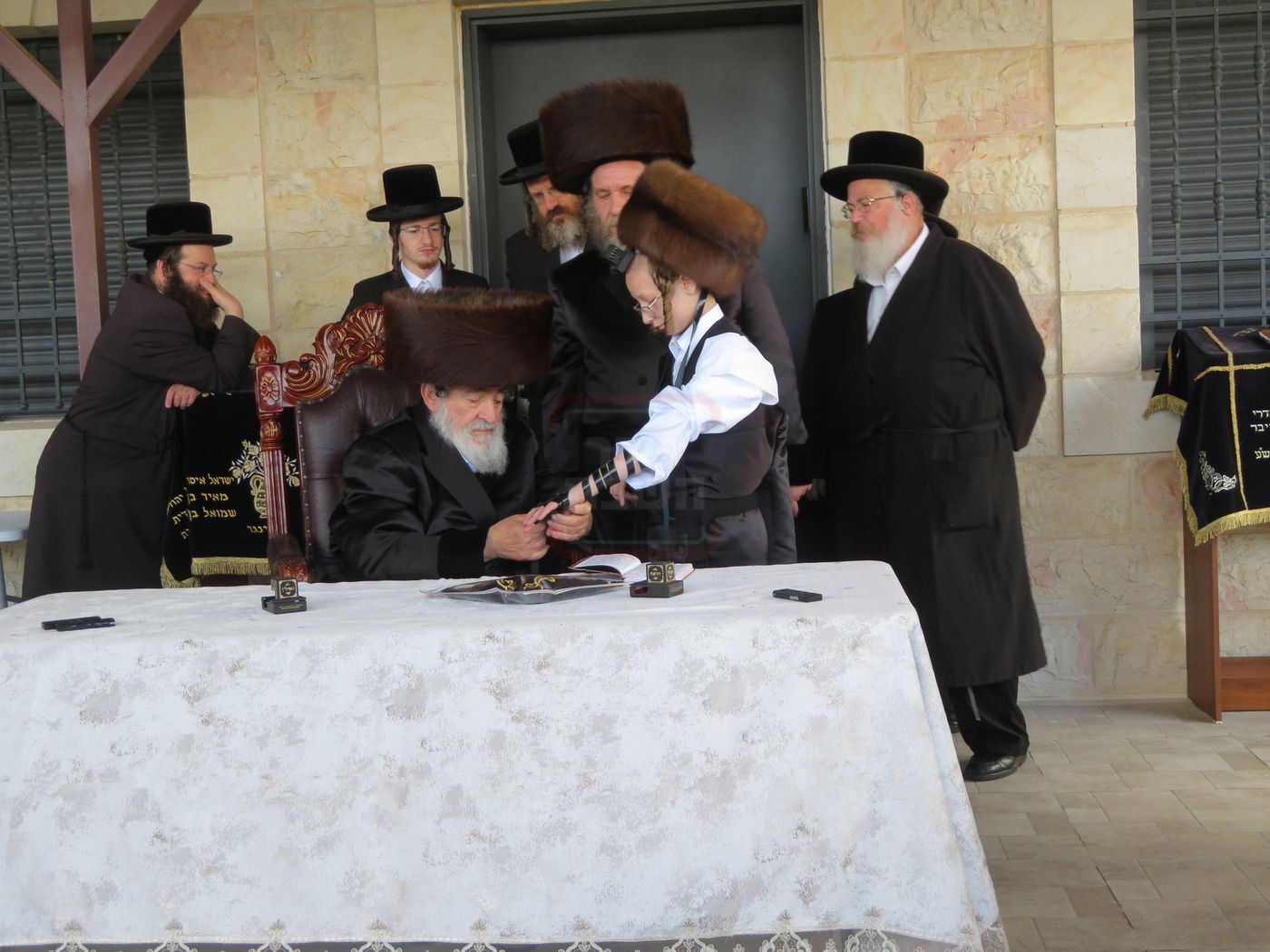 האדמו"ר מויז'ניץ בהנחת תפילין לנכדו משה יהושע הגר